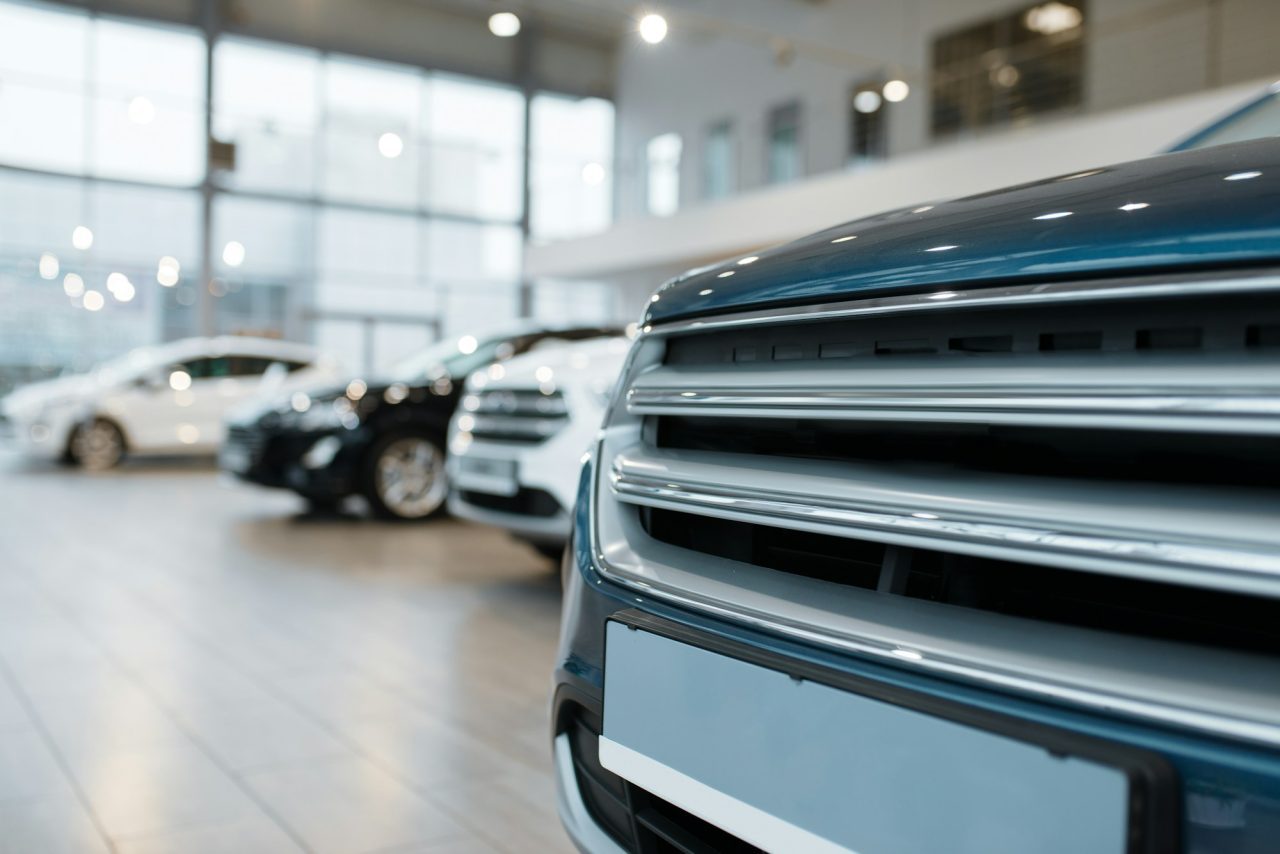 Toronto airport limo service luxury vehicle lineup with close-up front grille view in a modern showroom, representing premium and reliable airport transportation.